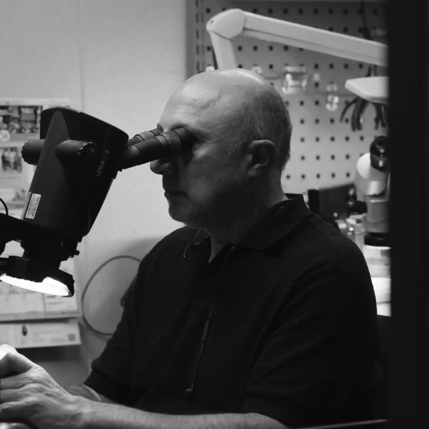 Jeweller inspecting fine jewellery under microscope in Toronto workshop